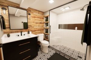 Modern bathroom with wood accent wall, white vanity, black hardware, patterned tile floor, and glass shower enclosure.
